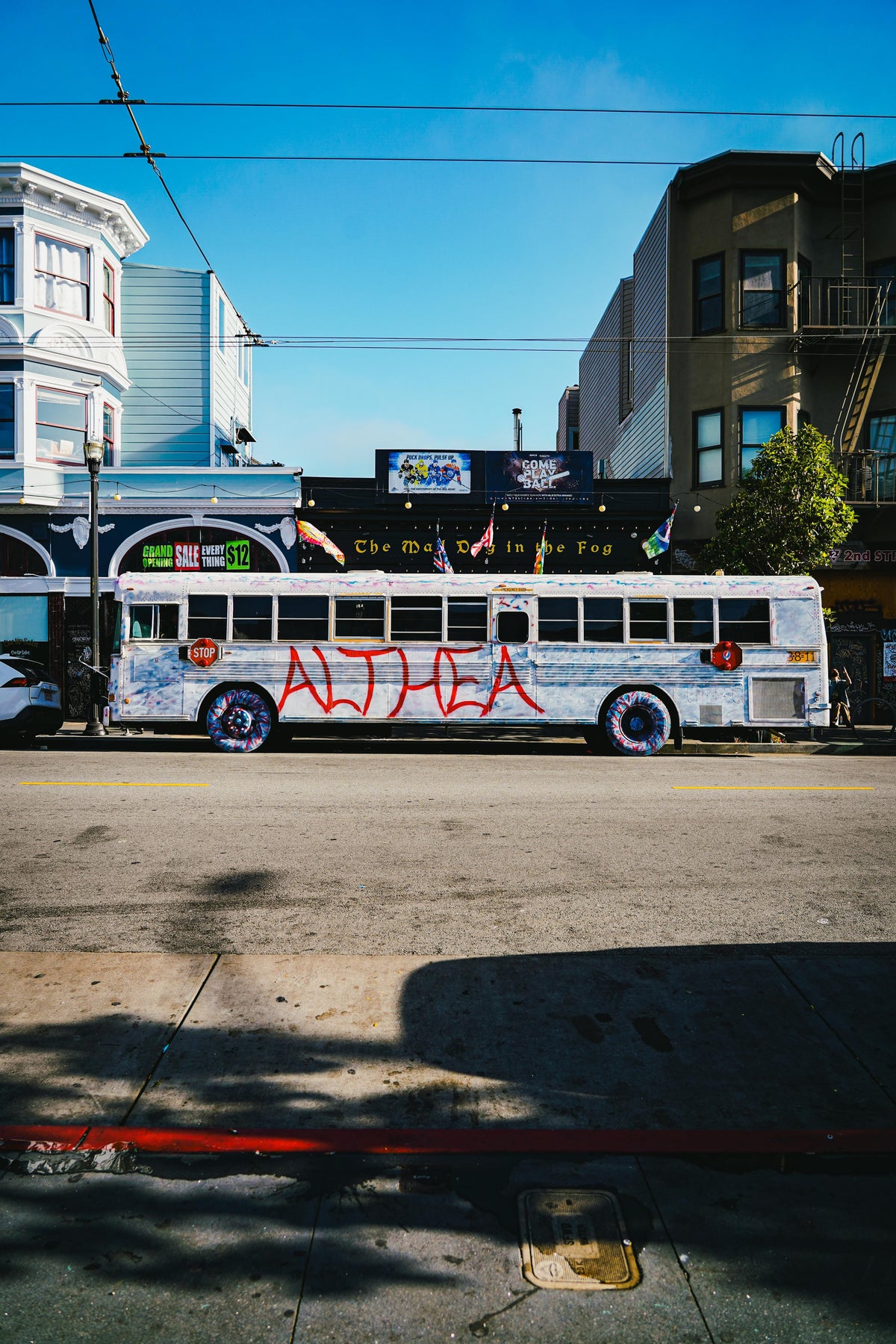 White tour bus painted with Althea parked on a San Francisco street